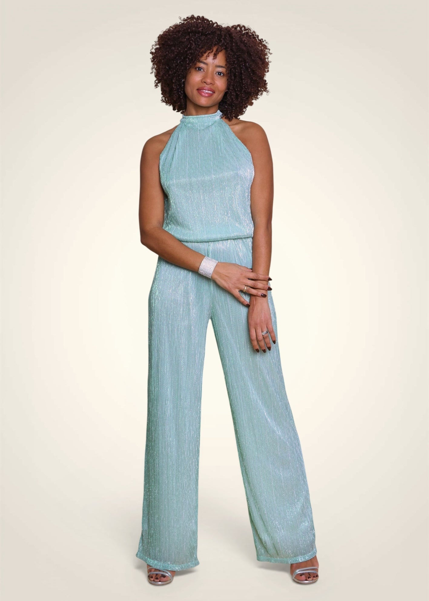 Combinaison de cérémonie en lurex plissé vert aqua avec coupe américaine portée de face.