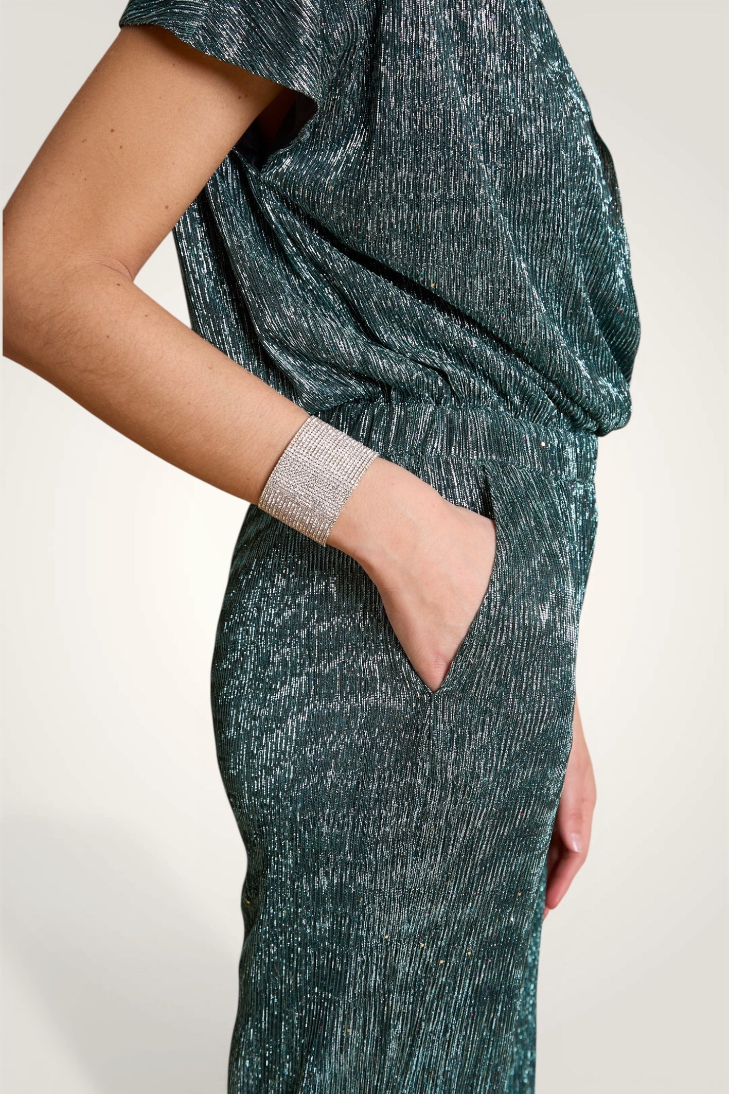 Détail rapproché sur la maille plissée en lurex brillant et léger.
