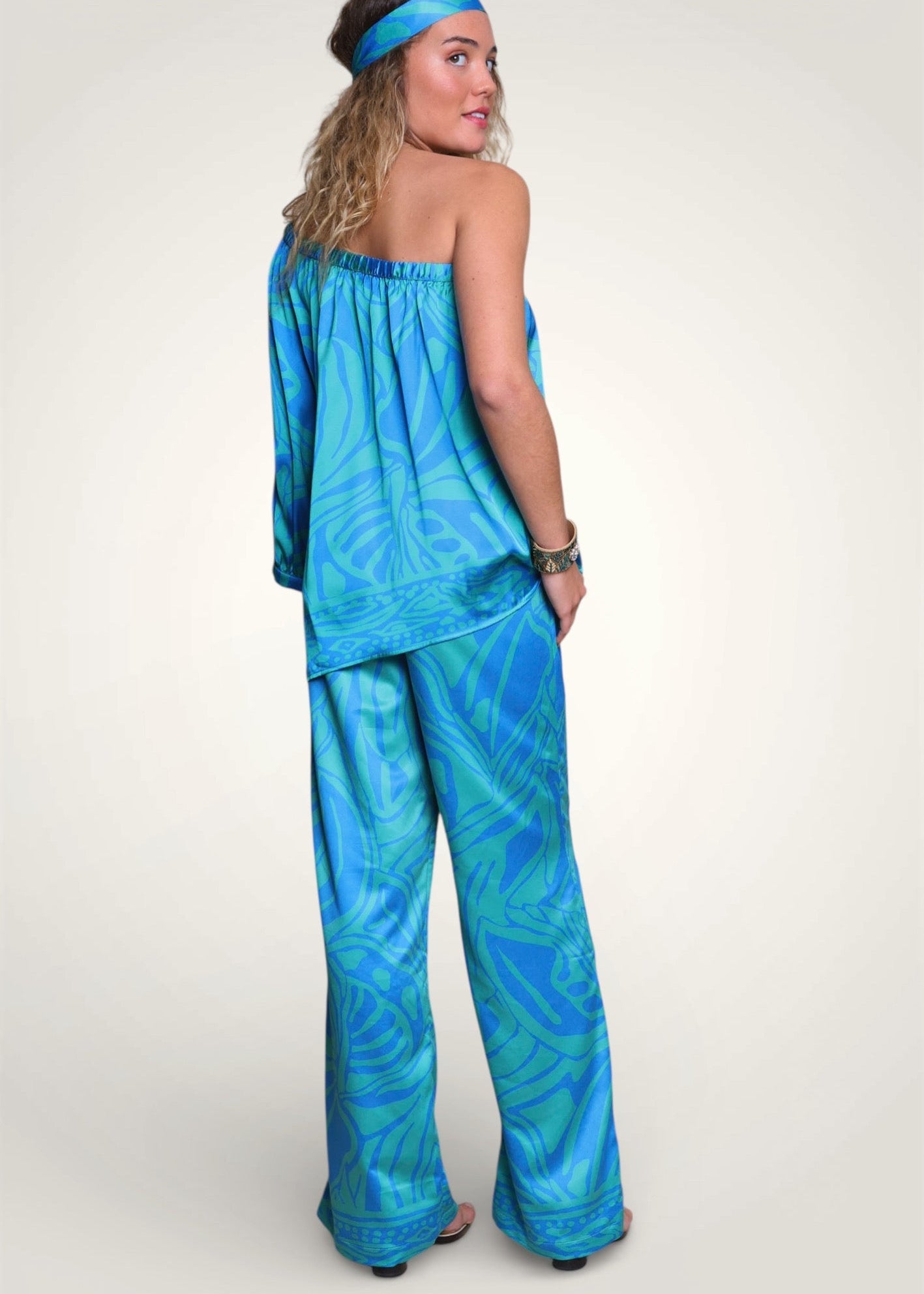 Dos de l'ensemble d'été Biarritz mettant en valeur le tombé soyeux du satin turquoise et vert.