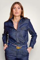Gros plan sur la chemise en jean de la combinaison et ses boutons pressions en nacre indigo.Vue de devant. 