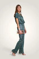 Vue de profil de la combinaison pantalon fluide avec jambes larges d'inspiration disco. Coloris vert canard.